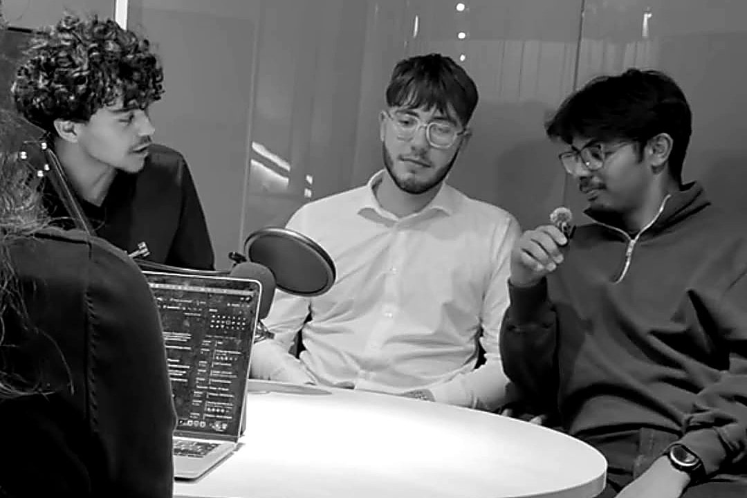 The three Sillage founders in a working session around a table, one speaking into a microphone.